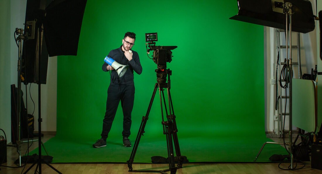 cameraman posing in green screen photo booth