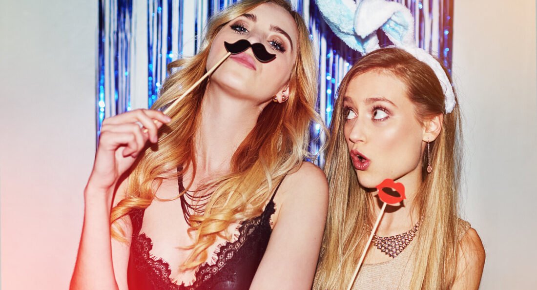 two women having fun in a photobooth